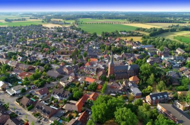 Aerial view of a village with several houses and a lot of woodland