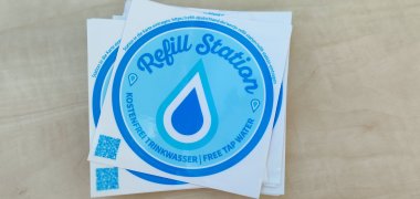 De blauwe en witte stickers van het Refill Germany initiatief geven aan dat hier gratis drinkwater beschikbaar is.