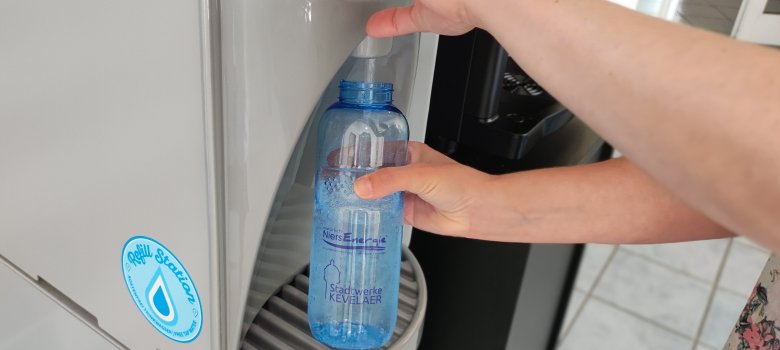 Een waterfles wordt gevuld bij de waterdispenser van Stadtwerke Kevelaer.