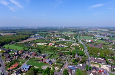 Luchtfoto van een dorp met verschillende huizen en veel bos