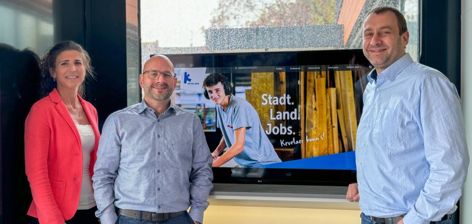 Stadsmedewerkers voor vitrine met brochures en scherm